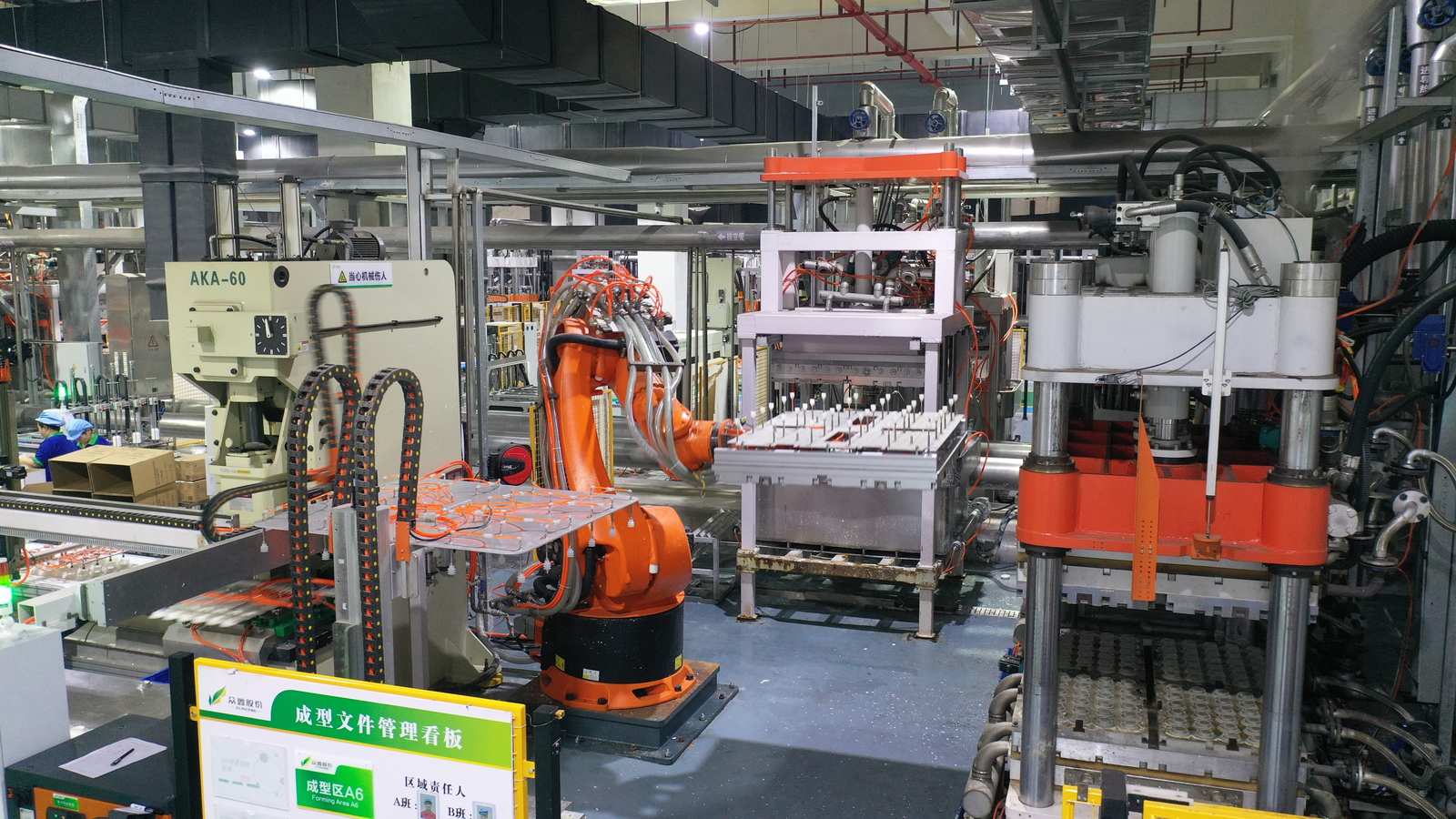 Robotic arm handling molded trays on a bagasse tableware production line
