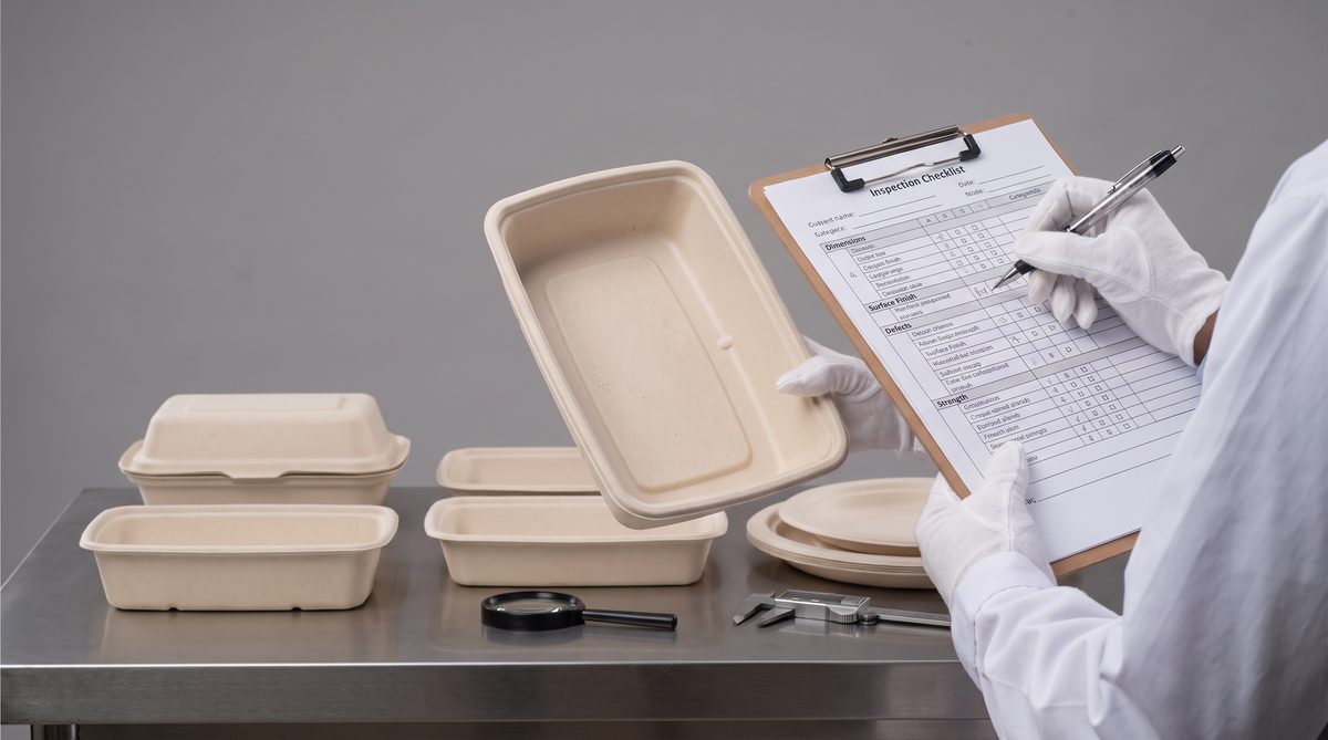Quality inspector checking bagasse tableware with AQL inspection sheet