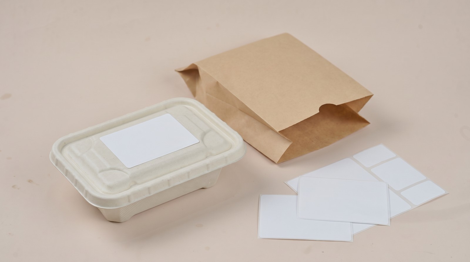 Bagasse container with a blank label and blank packaging for labelling compliance